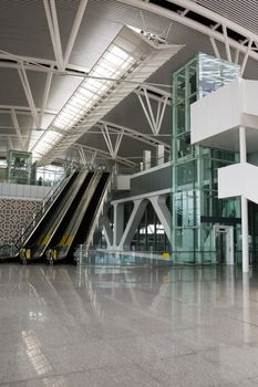 Modern business building interior with escalators and elevator