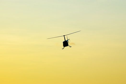 Helicopter flying over the sky at sunset