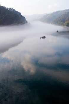 Fishing boat on the foggy river in Hunan province of China