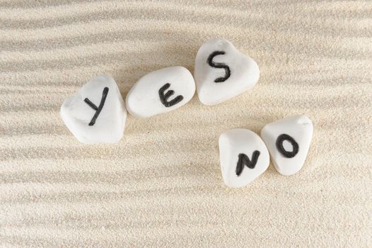 Yes no words carved on stones of the beach