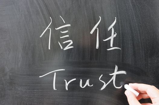 Trust word in Chinese and English written on the chalkboard