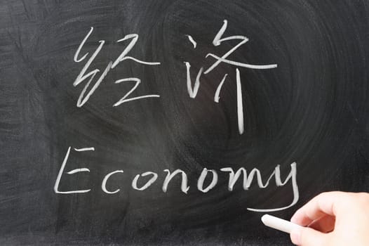 Bilingual economy word in Chinese and English written on the blackboard