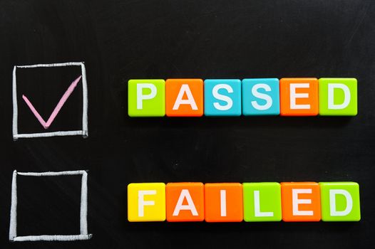 Passed or failed words made of blocks on blackboard