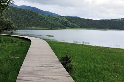 Plank road on the meadow near the lake in Shangri-la national park