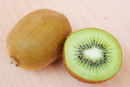 Fresh kiwis on wooden ground