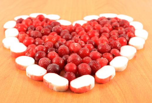 Frozen cranberries are laid out in the form of heart close-up