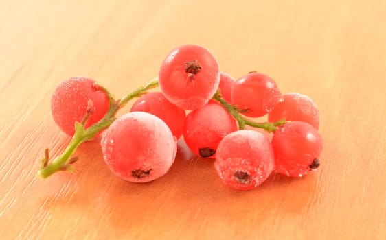 Frozen red currant close-up on wooden surface