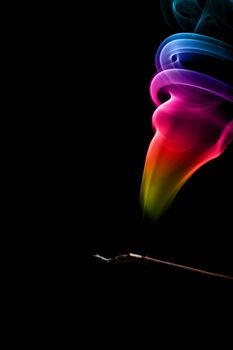 Incense Stick with Colorful Abstract Smoke Trail on black background