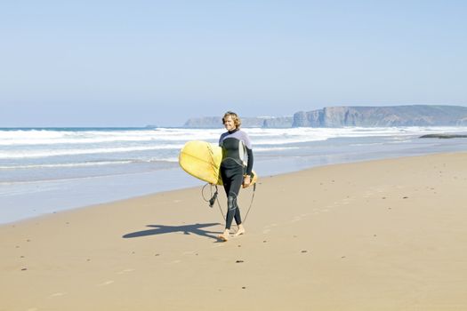 Surfer with his surfboard at the beach