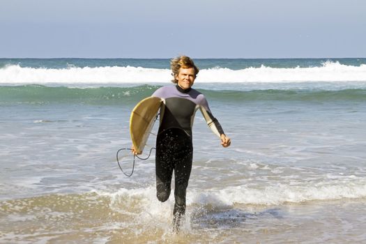 Surfer with his surfboard at the beach