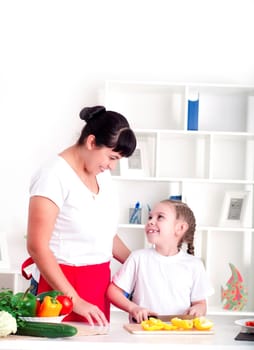 Mother and daughter cooking vegetable salad together