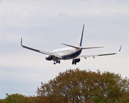 photograph of landing airplane - back view