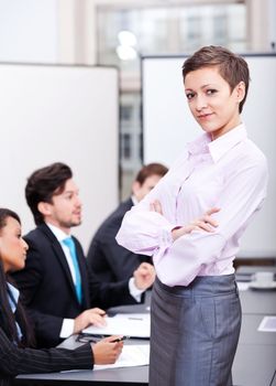 professional successful smiling business woman in office with team in background