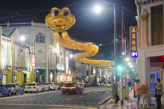 Singapore - January 11,  2013: Yellow snake made from traditional lanterns hanged over South Bridge Road just before Chinese New Year Celebration in Chinatown district of Singapore.