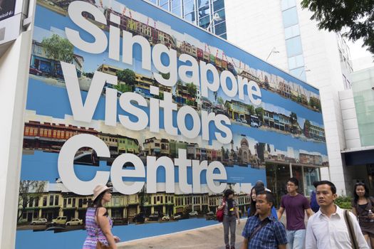 Singapore - January 12,  2013: Pedestrians walk along Singapore Visitors Centre wall on famous Orchard road in Singapore City.