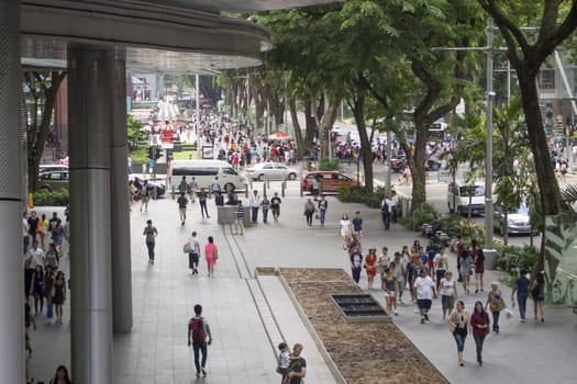 Singapore - January 12,  2013: Pedestrian crowds walk along iconic shopping street the famous Orchard Road in Singapore.