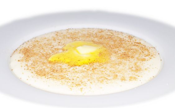 Porridge in a deep bowl with butter eye, cinnamon and sugar