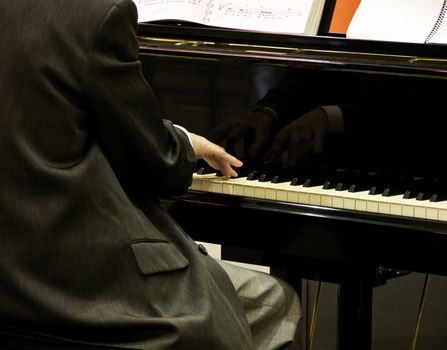 Close up of male hands playing piano.