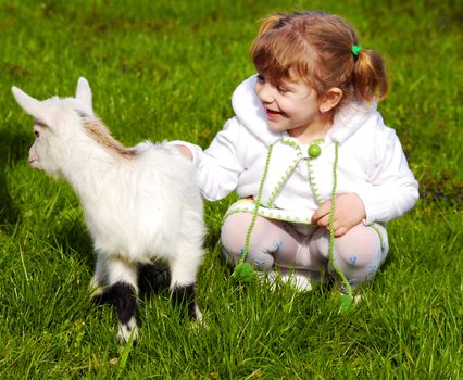 Beauty little girl and pet little goat