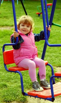 Playground with little girl on swing