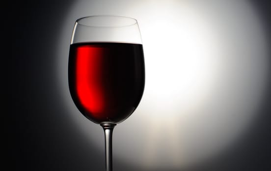 Closeup of red wine wineglass on dark background