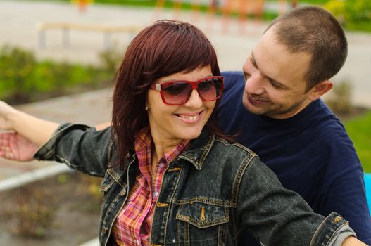 Good looking couple in love smiles each other outdoor