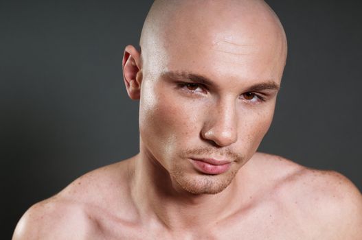 Studio portrait of shirtless muscled bald man