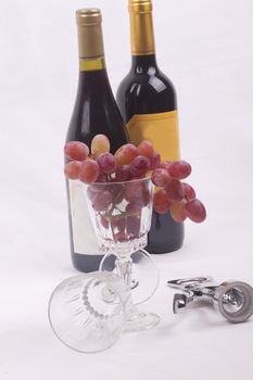 Bottle of red wine, and glass filled with grapes