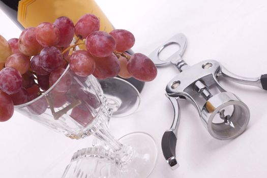 Bottle of red wine, and glass filled with grapes