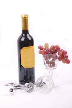 Bottle of red wine, and glass filled with grapes