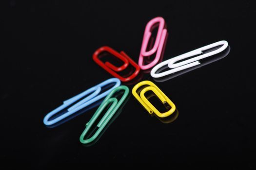 photo of colorfull paper clips on a black background