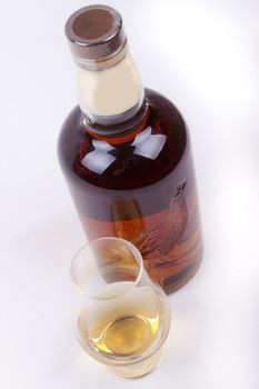 glass and bottle of whisky on a white background