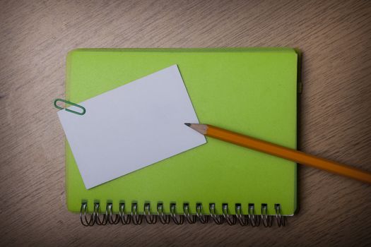green notebook on a wooden desk