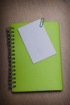 green notebook on a wooden desk