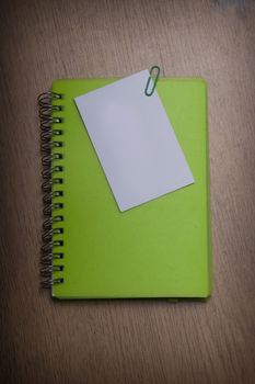 green notebook on a wooden desk