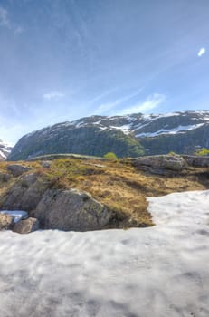 Picture of a mountain in the background with "old" snow in the foreground