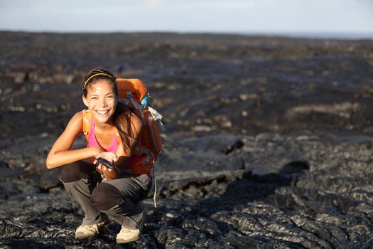 Hiker showing fresh cooled lava from Kilauea volcano around Hawaii volcanoes national park, Big Island, Hawaii, USA. Young asian woman hiking.