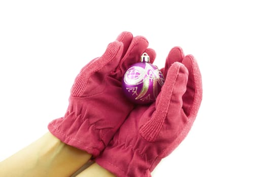 Female hands in pink gloves holding a Christmas ball