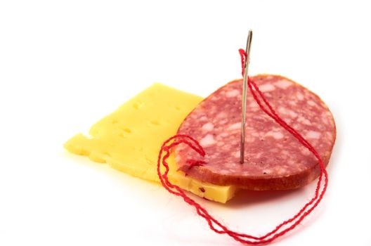 A piece of smoked sausage sewn to a firm cheese 