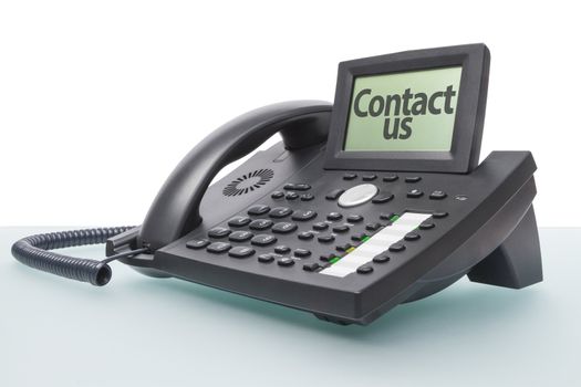 modern voip telephone on glas-topped desk saying CONTACT US