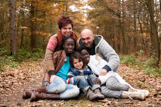 Happy family with foster children in the forest