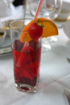 Red cocktail with orange and strawberry