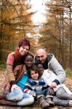 Happy family with foster children in the forest