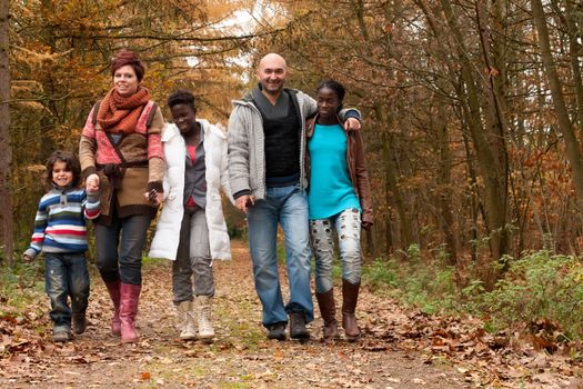 Happy family with foster children in the forest