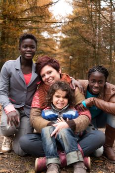 Happy family with foster children in the forest