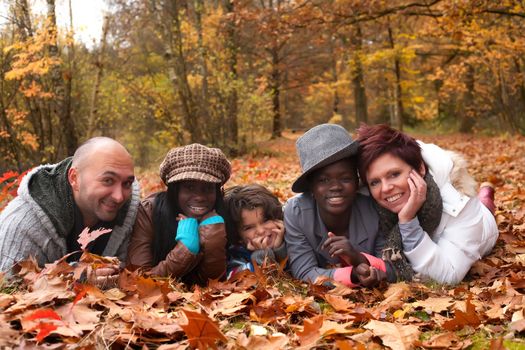 Happy family with foster children in the forest