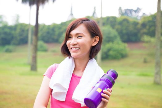 Asian girl taking a rest after jogging at outdoor park