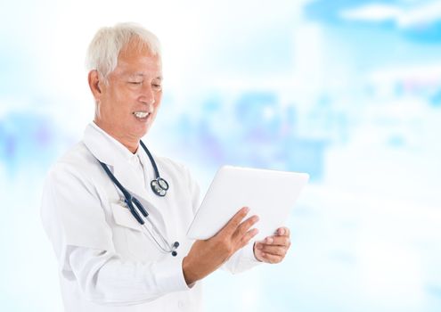 Asian senior doctor using tablet-pc inside hospital