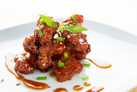 Chinese spare ribs on a plate isolated on white.