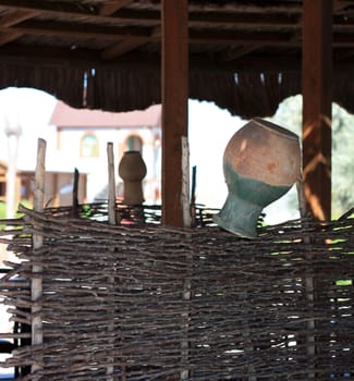 Decorative clay jugs on the fence wicker 